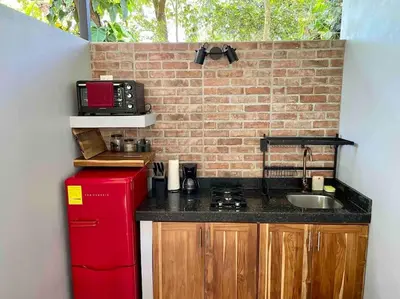 a kitchen with a sink and a red refrigerator at Industrial Studio with private Jacuzzi in Uvita