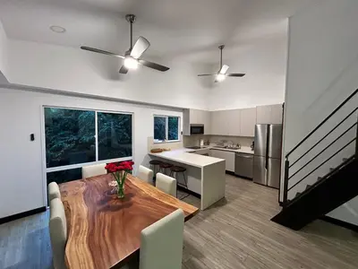 a kitchen and dining room with a wooden table and chairs at Playa Hermosa, Mistico, Surf, Bike, Hike, 4 Hab, Lagos, Familia in Jacó
