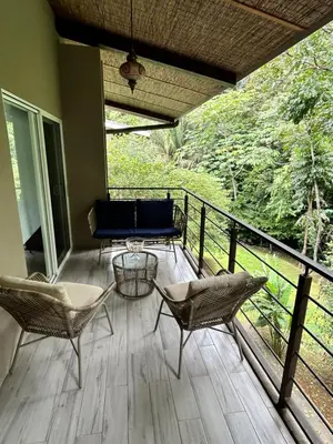 a porch with chairs and a table on a balcony at Playa Hermosa, Mistico, Surf, Bike, Hike, 4 Hab, Lagos, Familia in Jacó