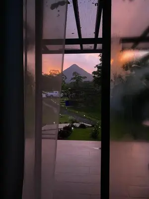 a view of a mountain through a glass door at Natura Bungalows in Fortuna