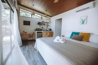 a bedroom with two beds and a kitchen in it at Natura Bungalows in Fortuna
