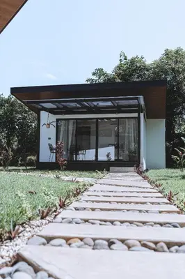 a house with a stone walkway leading to a patio at Natura Bungalows in Fortuna