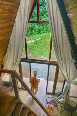 a man standing in a room looking through a window at Pozas y Cascadas La Presa Habitación 2 in Ángeles