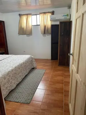 a bedroom with a bed and a window and a door at Hermoso apartamento en Quepos/ Manuel Antonio. in Quepos