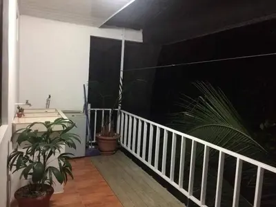 a balcony with potted plants and a white railing at Hermoso apartamento en Quepos/ Manuel Antonio. in Quepos