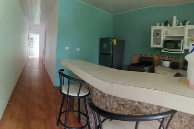 a kitchen with a counter and two bar stools at Hermoso apartamento en Quepos/ Manuel Antonio. in Quepos