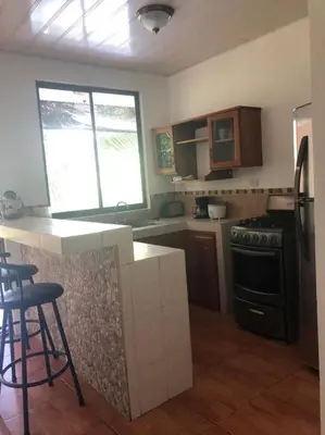 a kitchen with a stove and a counter top at Hermoso apartamento en Quepos/ Manuel Antonio. in Quepos