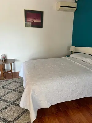 a white bed in a room with a table at Estudio como en casa in Quepos
