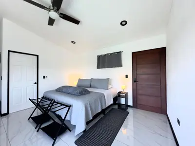 a bedroom with a bed and a ceiling fan at Black & White Apartments in Monteverde Costa Rica