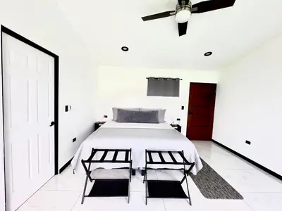 a bedroom with a bed and a ceiling fan at Black & White Apartments in Monteverde Costa Rica