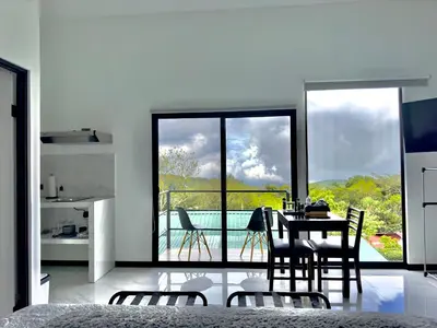 a kitchen and dining room with a table and chairs at Black & White Apartments in Monteverde Costa Rica