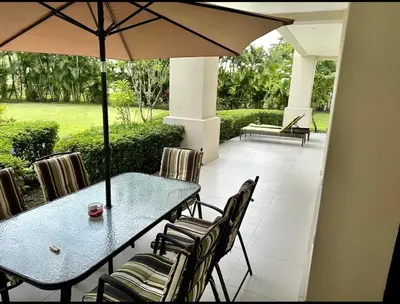a table and chairs with an umbrella on a patio at Private Modern Condo by Jac Beach in Jacó