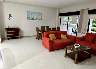 a living room with a red couch and a table at Private Modern Condo by Jac Beach in Jacó
