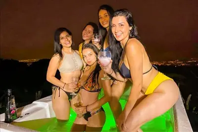 a group of women posing for a picture at a party at Bus Hotel with HotTube in the middle of mountain in Sarchí