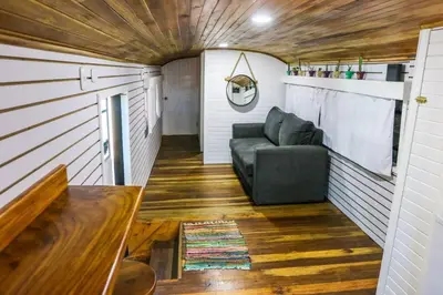 a living room with a couch in a tiny house at Bus Hotel with HotTube in the middle of mountain in Sarchí