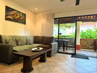 a living room with a couch and a table at Peaceful Bliss Condo inside a 6 pool Complex in Coco
