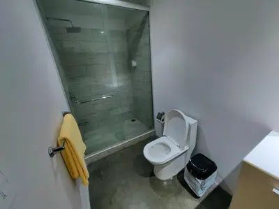 a bathroom with a toilet and a glass shower at 906A URBN Barrio Escalante Estudio con A/C y Parqueo in San José