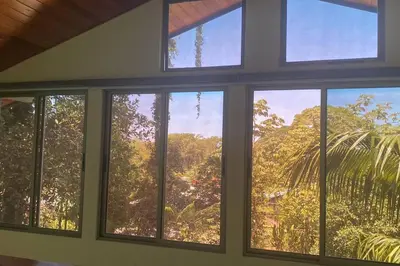 a room with three windows with a view of trees at Casita Colibri–Mile to the Beach–Cable&Fiber Wifi! in Uvita