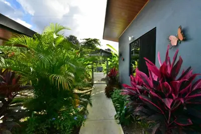 a garden with pink plants and a building at Raya in Matapalo