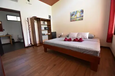 a bedroom with a bed with two red roses on it at Raya in Matapalo