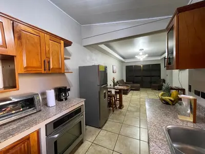 a kitchen with a stainless steel refrigerator and a living room at Casa Bella Vista in Quepos