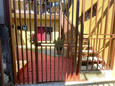 a metal gate with a potted plant in front of a building at Casa Bella Vista in Quepos