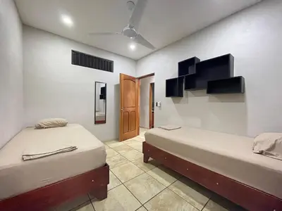 a room with two beds and a door at Casa Bella Vista in Quepos