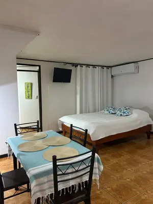 a room with two beds and a table and chairs at SilvaMar in Puntarenas