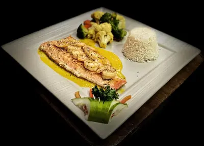 a plate of food with a piece of fish and vegetables at Hotel Mirador de Quetzales in Providencia