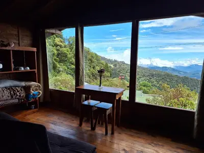 a room with a table and a view of mountains at Hotel Mirador de Quetzales in Providencia