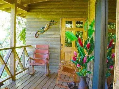 a porch of a house with a chair and a window at CASITAS GINGER in Quepos