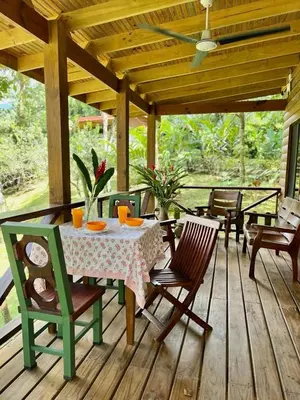 a patio with a table and chairs on a wooden deck at CASITAS GINGER in Quepos
