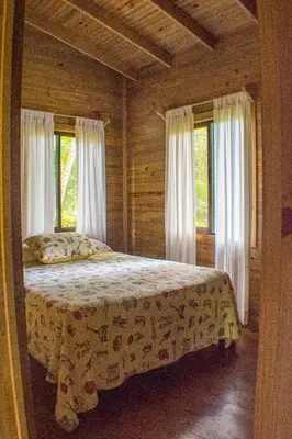 a bedroom with a bed in a room with windows at CASITAS GINGER in Quepos