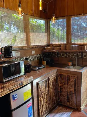 a kitchen with a refrigerator and a microwave at Cabañas Tierra Fértil #2 in Montaña
