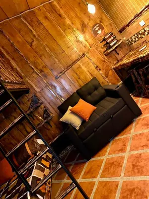 a black couch with an orange pillow in a room at Cabañas Tierra Fértil #2 in Montaña