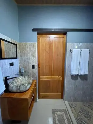 a bathroom with a shower and a wooden door at Casa Sios San Luis, Monteverde in Monteverde Costa Rica