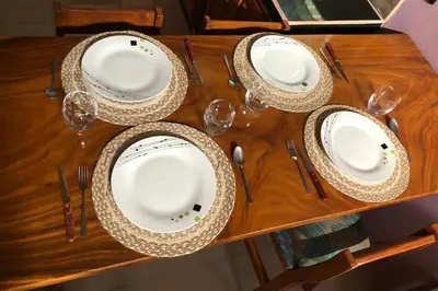 a wooden table with plates and wine glasses on it at Casa Sios San Luis, Monteverde in Monteverde Costa Rica