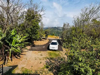 a white car parked on the side of a road at Casa Sios San Luis, Monteverde in Monteverde Costa Rica