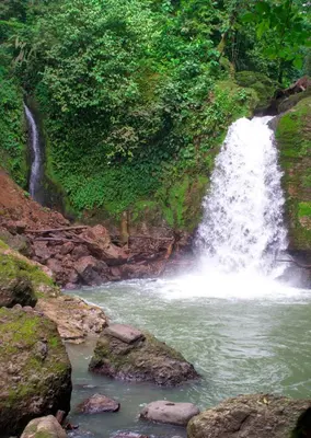 a waterfall on the side of a mountain with rocks at Casa Rancho Verde in Monterrey