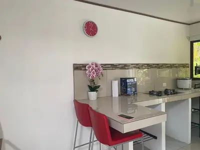 a kitchen with a table with red chairs and a clock at Casa Zion in San Juanillo