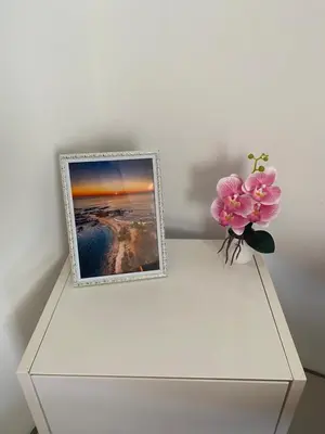 a white dresser with a picture and a flower in a vase at Casa Zion in San Juanillo