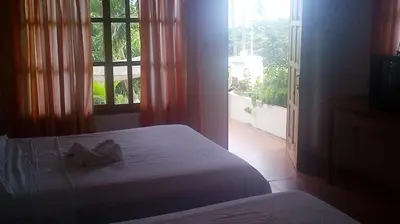 a bedroom with a bed and a large window at Hotel Three Monkeys in Montezuma