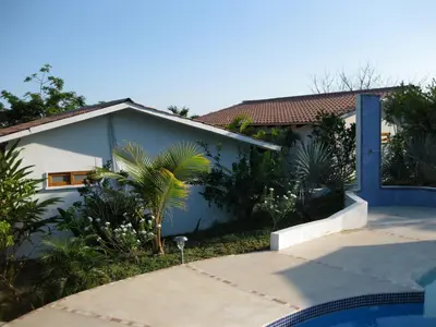 a blue and white house with a palm tree in front of it at Hotel Three Monkeys in Montezuma