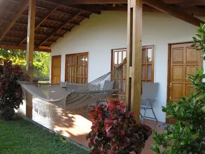 a hammock on the porch of a house at Hotel Three Monkeys in Montezuma