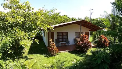a small house in the middle of a garden at Hotel Three Monkeys in Montezuma