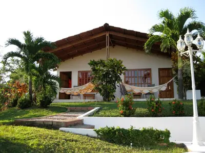 a house with a hammock in front of it at Hotel Three Monkeys in Montezuma