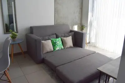 a gray couch with pillows in a living room at 0404 iFreses estudio con Aire Acondicionado y Parqueo in Curridabat