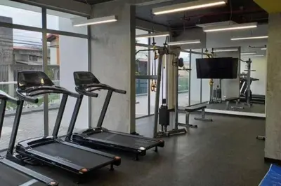 a gym with cardio machines and a flat screen tv at 0404 iFreses estudio con Aire Acondicionado y Parqueo in Curridabat