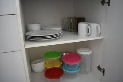 a white shelf with plates and cups and bowls at 0404 iFreses estudio con Aire Acondicionado y Parqueo in Curridabat
