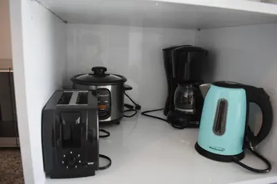 a kitchen counter with various appliances on a shelf at 0404 iFreses estudio con Aire Acondicionado y Parqueo in Curridabat